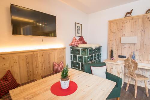 a living room with a table and a television at Hotel Magdalena im Zillertal - Urlaub mit Hund in Ried im Zillertal