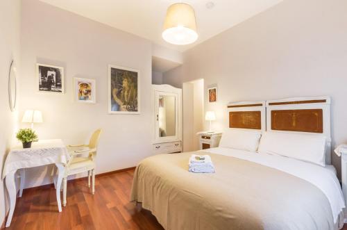 ein weißes Schlafzimmer mit einem Bett und einem Tisch in der Unterkunft Liberty Trastevere B&B in Rom