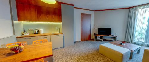a kitchen and a living room with a table at Ruskovets Thermal SPA & Ski Resort in Bansko
