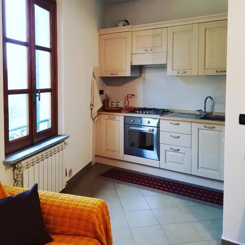 a kitchen with white cabinets and a stove at La casa di Gina in Sassello