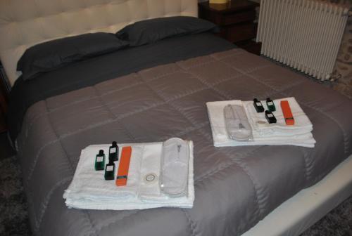 a bed with towels and bottles of wine on it at Bed & Breakfast StudioArcodia- in San Marco dʼAlunzio