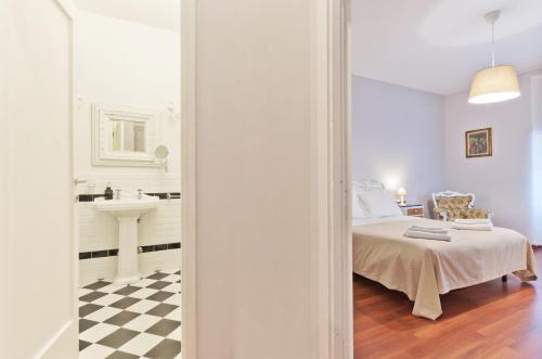 a bedroom with a bed and a bathroom with a sink at Liberty Trastevere B&B in Rome