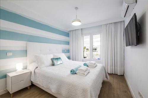 プラヤ・オンダにあるFlower Beach Suite 1のベッドルーム1室(青と白のストライプのベッド1台付)