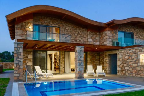 a house with a swimming pool in front of it at Estrella Villas in Lartos