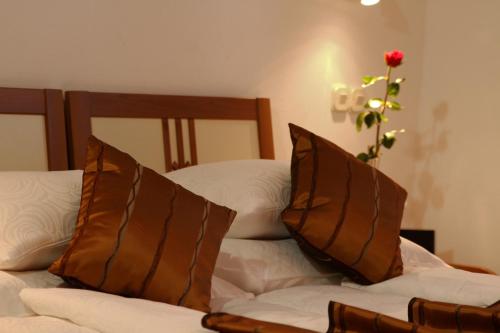 two beds with pillows and a vase with a flower at Apartments AMORE in Bol