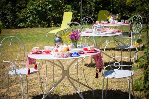 Deux tables et des chaises avec de la nourriture et des fleurs sur elles dans l'établissement La Caramellina, à Cortazzone