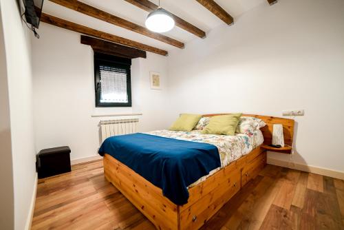 1 dormitorio con cama de madera con sábanas azules en LA HUERTA DEL DUERO, en Villamarciel