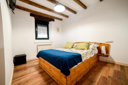 VillamarcielにあるLA HUERTA DEL DUEROのベッドルーム1室(木製ベッド1台、青いシーツ付)