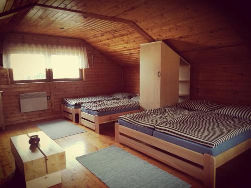 - une chambre avec 3 lits dans une cabane en bois dans l'établissement Chatka Ivanka, à Partizánska ľupča