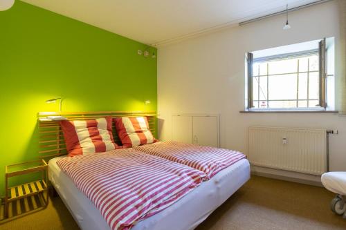 a bedroom with a bed with a green wall at Alte Falknerei in Weimar