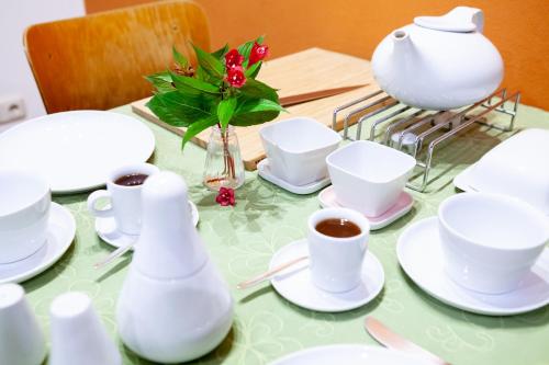 a table with white dishes and a vase of flowers at Alte Falknerei in Weimar