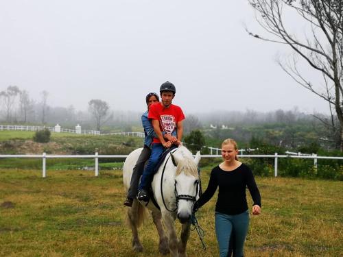 a woman leading a boy riding on a horse at TNiqua Stable Inn in Plettenberg Bay