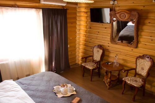 een slaapkamer met een bed, een tafel en een spiegel bij Hotel Fregat in Kiev