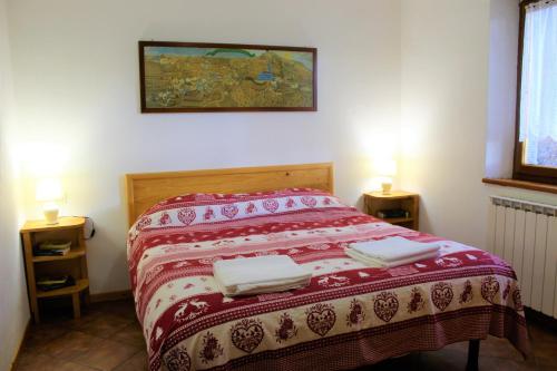 Una cama en una habitación con dos toallas. en Chalet Abetone in Tuscany, en Abetone