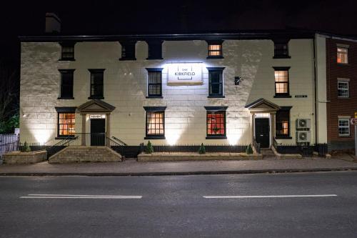 ein weißes Gebäude mit einem Schild an der Vorderseite in der Unterkunft The Kirkfield Hotel in Newton-le-Willows