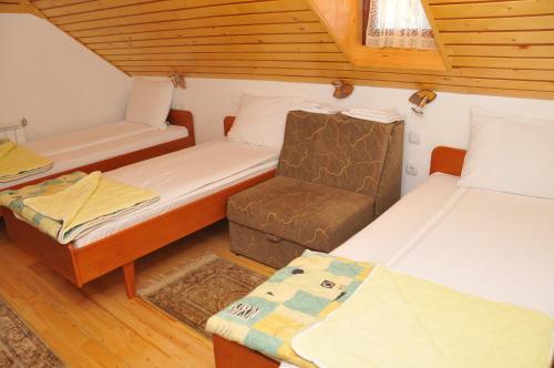 a small room with two beds and a chair at Vila Jelena Zlatar Nova varoš in Brdo