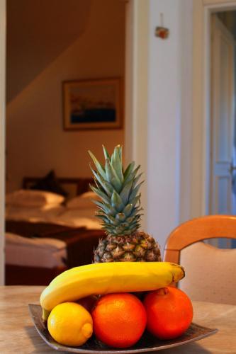 a pineapple and fruit on a plate on a table at Apartments AMORE in Bol