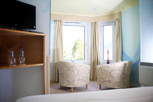 a hotel room with two chairs and a window at The Lodge On The Loch Onich in Onich