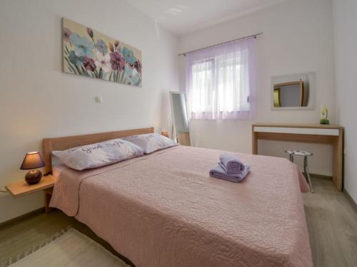 a bedroom with a bed with a purple towel on it at Apartman Nina in Kruševo