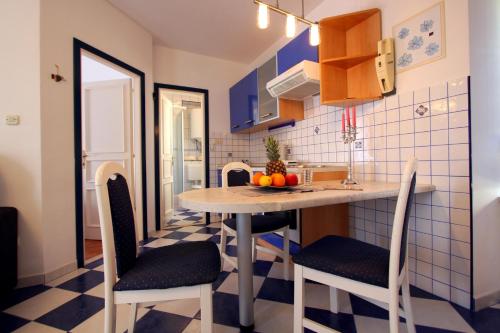 a kitchen with a table and chairs in a room at Apartments AMORE in Bol