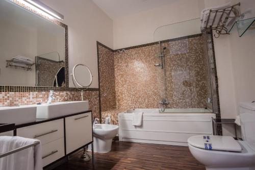 a bathroom with a sink, toilet and bathtub at Hotel Palacio Garvey in Jerez de la Frontera