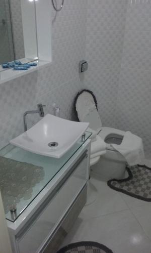 a bathroom with a toilet and a sink at Flat Cavalinho Branco 2B1 in Águas de Lindóia