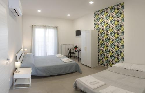 a bedroom with two beds and a painting on the wall at Villa Ulivi B&B in Pontecagnano