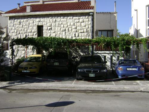 three cars parked in a parking lot in front of a building at Beach apartment in the center of Brela in Brela
