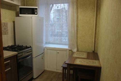 アルハンゲリスクにあるКвартира в центре - Тимме 9 корпус 3の小さなキッチン(白い冷蔵庫付)、窓が備わります。