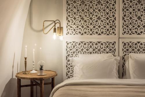 a bedroom with a bed and a table with two candles at Cocoon Suites in Imerovigli