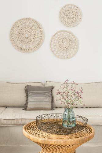 a living room with a couch and a table with flowers at Cocoon Suites in Imerovigli