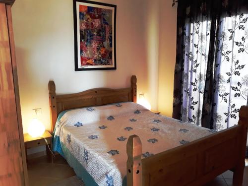 1 dormitorio con 1 cama de madera y 2 lámparas en Casa Bahia 7, en Santa Maria