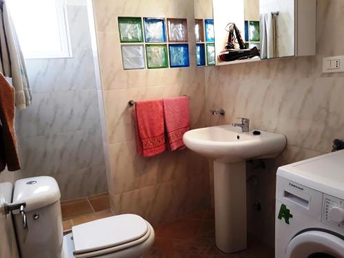 uma casa de banho com um WC branco e um lavatório. em Casa Bahia 7 em Santa Maria