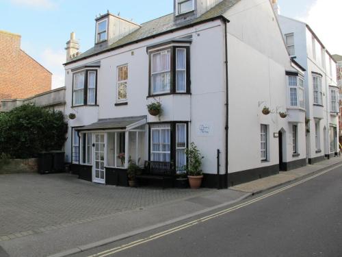 a white building on the side of a street at Stone's Throw Guest House in Weymouth