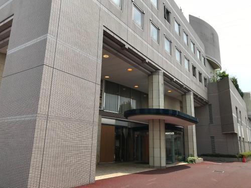 a large brick building with a circular entry way at Business Hotel Noda in Noda