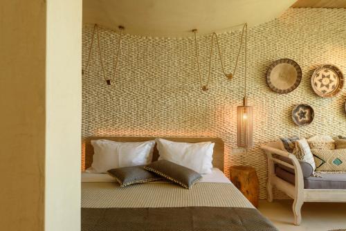 a bedroom with a bed and a chair at Divelia East in Imerovigli