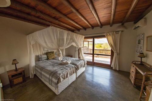 una camera con letto e soffitto in legno di Stunning Mountain Views From A 3-Bedroom Home With Pool a Hoedspruit