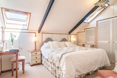 a bedroom with a bed and a desk and a window at Cadleigh Manor in Ivybridge