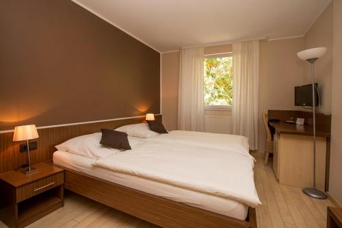 a bedroom with a large white bed and a window at Haus Fabry in Hilden