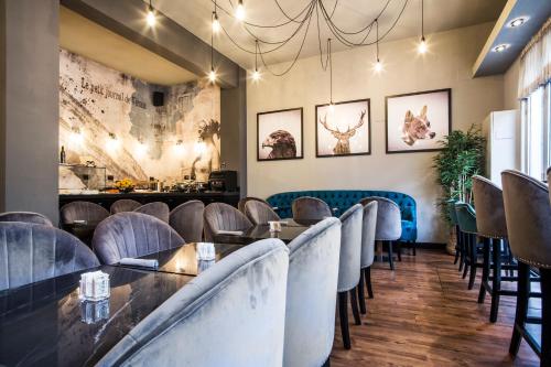 a dining room with chairs and tables and a wall with paintings at Verona House Aparthotel in Verona