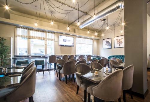 a dining room with tables and chairs and a tv at Verona House Aparthotel in Verona
