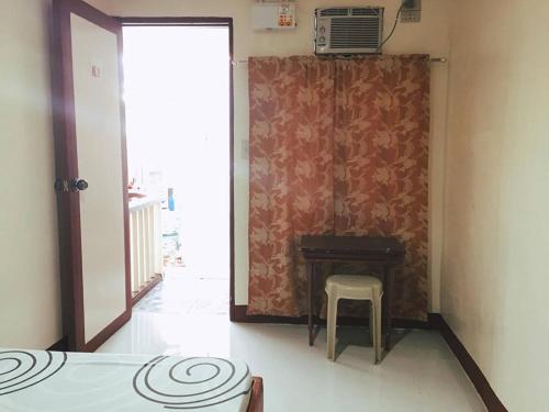 a room with a table and a chair next to a door at Krizma Inn in El Nido
