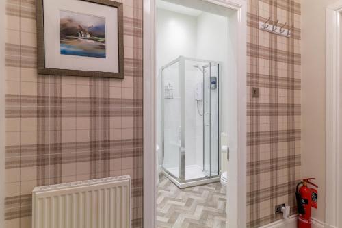 a bathroom with a shower and a toilet in it at West Highland Apartments Milngavie - The Nevis in Milngavie