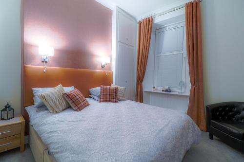 a bedroom with a bed with pillows and a window at West Highland Apartments Milngavie - The Nevis in Milngavie