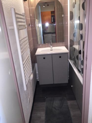 une salle de bain avec un lavabo blanc et un miroir dans l'établissement LE CHRISTIANIA Les bergers, à L'Alpe-d'Huez