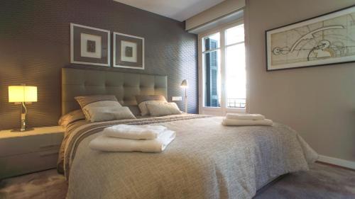a bedroom with a large bed with towels on it at Downtown Design Apartment in Donostia-San Sebastián