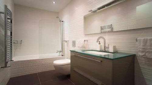 a bathroom with a toilet and a sink and a tub at Downtown Design Apartment in San Sebastián