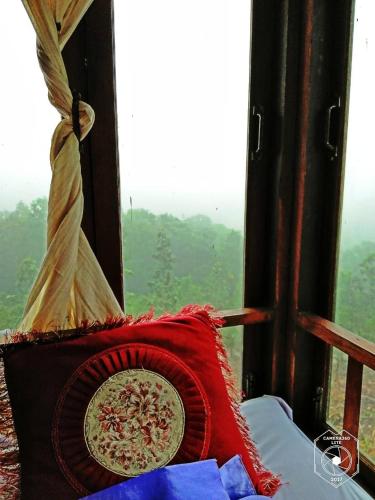 a pillow sitting on a bed in front of a window at Khunyuam Resort in Ban Khun Yuam