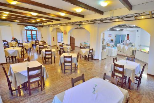a dining room with tables and chairs and white tables and chairsktop at Elena Beach Hotel in Kissamos