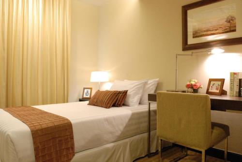 a hotel room with a bed and a chair at The Narathiwas Hotel & Residence Sathorn Bangkok in Bangkok